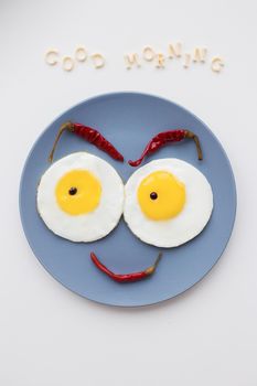 cheerful breakfast, two eggs on a plate, the inscription Good Morning.