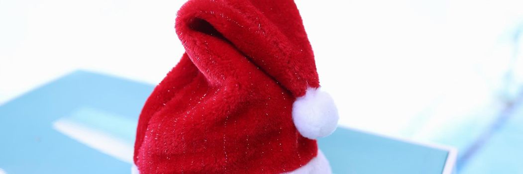 Red santa claus hat lying on sunbed closeup. New Years holidays concept