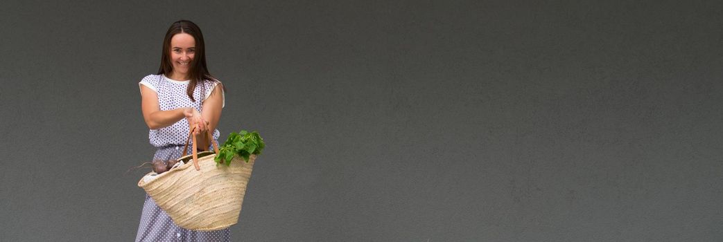 woman is holding straw back for shopping with products without plastic packaging. minimalistic concept