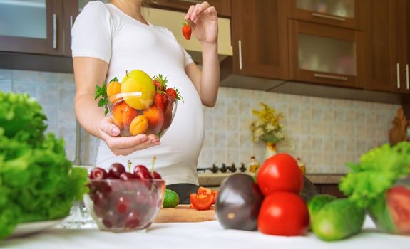 A pregnant woman eats vegetables and fruits. Selective focus. Food.