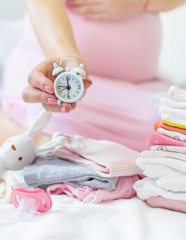 Pregnant woman with an alarm clock. Selective focus. people.