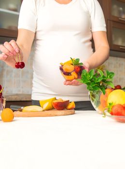 A pregnant woman eats fruit. Selective focus. food.