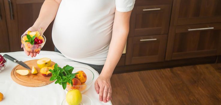 A pregnant woman eats fruit. Selective focus. food.