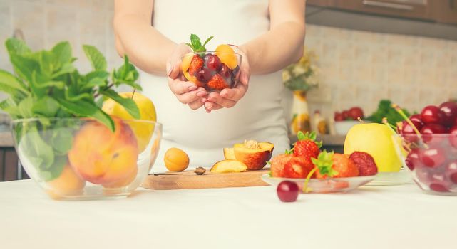 A pregnant woman eats fruit. Selective focus. food.
