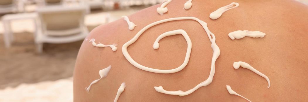 Sun painted with sunscreen on back of man closeup. Uv protection skin concept