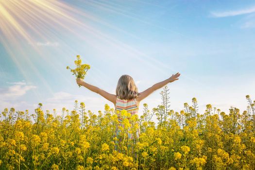 A child in a yellow field, mustard blooms. Selective focus. nature.