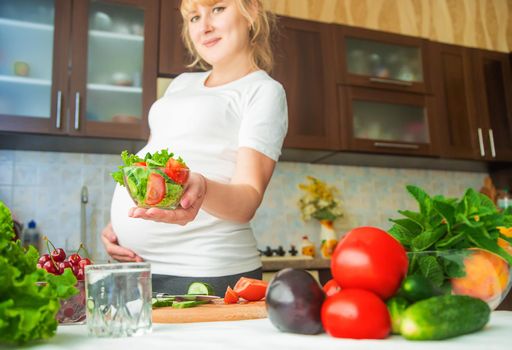 A pregnant woman eats vegetables and fruits. Selective focus. Food.