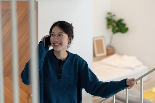 Portrait of beautiful asian woman sitting on stairs and making phone call
