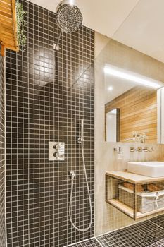 Contemporary bathroom with bathtub and glass shower cabin with light and sink with mirror,beige tile and white ceiling