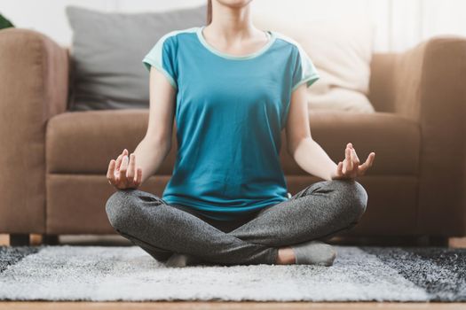 Young woman practicing yoga follow teacher in laptop online class at home. Calmness and relax concept