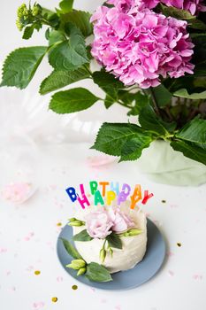 Very beautiful bento cake, decorated with fresh eustoma flowers on the background of sweets and the inscription happy birthday, balloons, flowers. Holiday concept