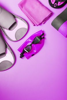 Equipment for swimming in the pool and in the sea on a pink background, for training