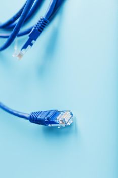 Blue Ethernet Cable Connectors Patch cord cord close-up isolated on a blue background with free space