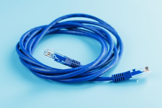 A coil of RJ45 Cat.6 Ethernet Network Internet Cable isolated on a blue background with free space