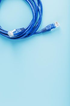 A coil of RJ45 Cat.6 Ethernet Network Internet Cable isolated on a blue background with free space