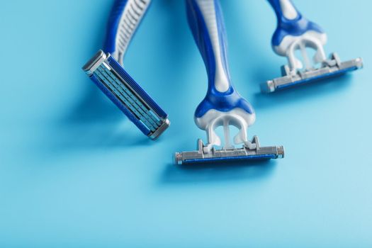 Blue shaving machine with sharp blades on the background of ice cubes close-up. The concept of cleanliness and frosty freshness