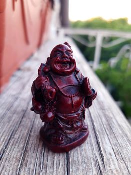 Netsuke Hotei from ceramics on a gray background close-up.