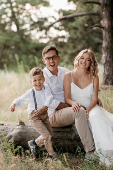 happy family three dad mom and son on a walk in the woods