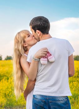 pregnant woman and man hold baby shoes. Selective focus. nature.