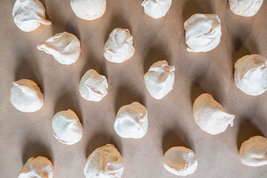 Homemade french milk-colored meringues on crumpled craft paper. flatley composition: delicious homemade meringues on craft paper