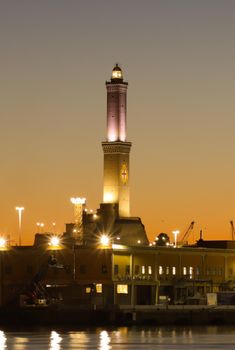 Genova, Italy - July 02, 2022: View of the city and the old harbor (Porto Antico) by night. City lights reflection over the water.