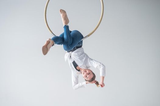 Caucasian woman in casual clothes on an aerial hoop