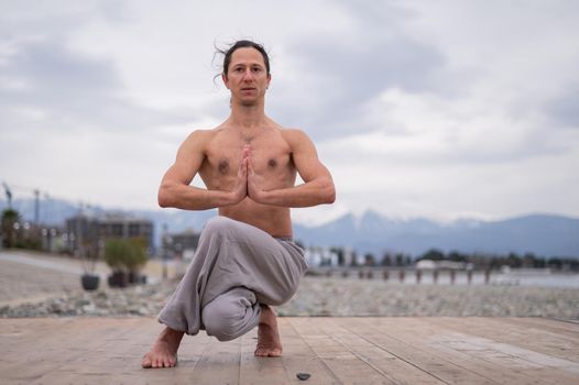 Caucasian man practices martial arts outdoors. balance and meditation