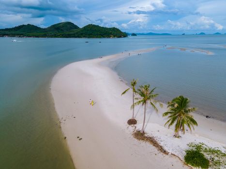 couple of men and women walking on the beach at the Island Koh Yao Yai Thailand, beach with white sand and palm trees.