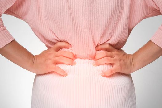 Woman holding hands on stomach with menstrual pain, abdominal pain, stomach ache, food poisoning on white background. close up. Health problems