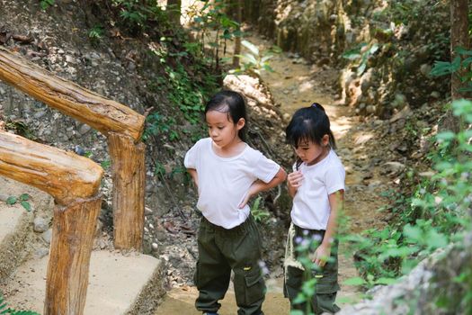 Asian tourist family, two sisters rest while traveling to Pha Chor is high soil canyon cliffs at Mae Wang National parks in Chiang Mai,Thailand. Travel and lifestyle concepts