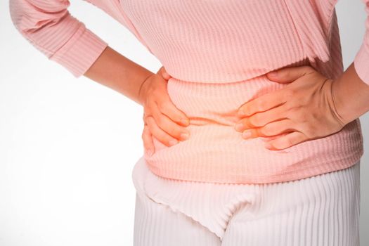 Woman holding hands on stomach with menstrual pain, abdominal pain, stomach ache, food poisoning on white background. close up. Health problems