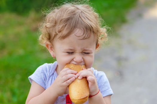 A child eats bread in the park. Selective focus. kid.