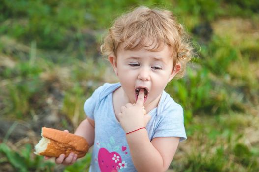 A child eats bread in the park. Selective focus. kid.
