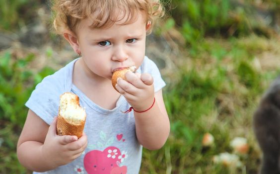 A child eats bread in the park. Selective focus. kid.