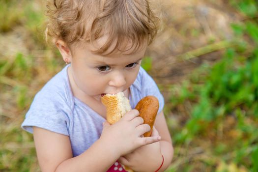 A child eats bread in the park. Selective focus. kid.