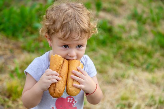 A child eats bread in the park. Selective focus. kid.
