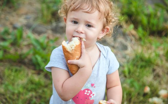 A child eats bread in the park. Selective focus. kid.