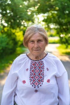 Grandmother in Ukrainian embroidered clothes. Selective focus. Nature.