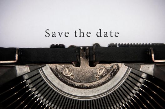 Save the date text typed on an old vintage typewriter. Conceptual
