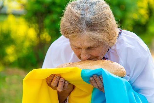 Grandmother with Ukrainian bread in her hands. Selective focus. Food.