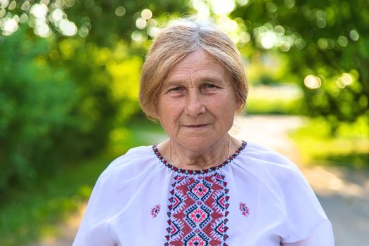 Grandmother in Ukrainian embroidered clothes. Selective focus. Nature.
