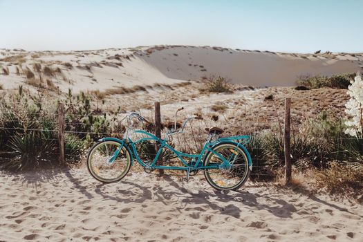 Blue bicycle standing on dune on the sea coast