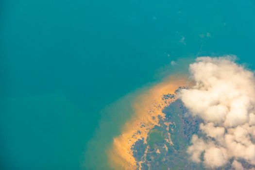 Aerial photo of Farmland .a golden sandy beach immersed in sunny greenery, surrounded by blue water. View from the plane. View from the plane High quality photo