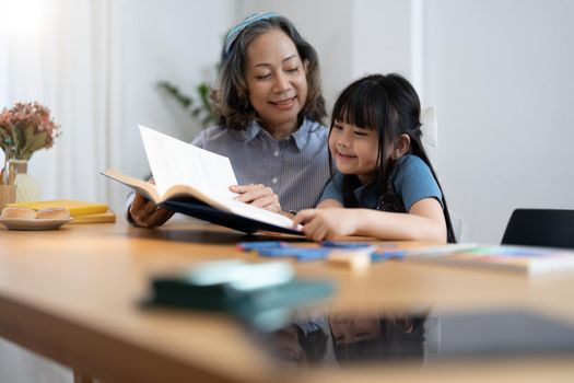 grandchild granddaughter grandma grandmother reading book girl senior.