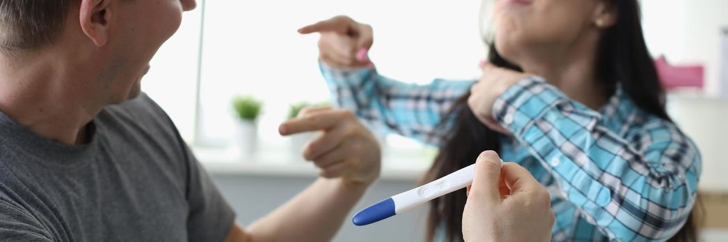 Man and woman communicating with pregnancy test in hands. Family and parents concept