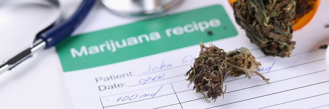 Jar with dried marijuana leaves and recipe lying on doctor table closeup. Cannabis based narcotic drugs concept