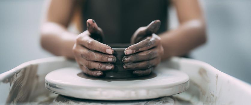 The woman's hands close up, the masterful studio of ceramics works with clay on a potter's wheel