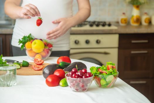 A pregnant woman eats vegetables and fruits. Selective focus. Food.