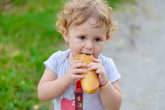 A child eats bread in the park. Selective focus. kid.