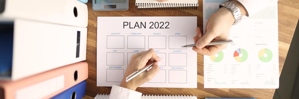 Business man and woman making plan for 2022 closeup top view. Business planning concept